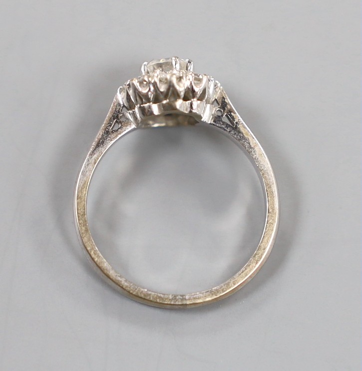 A modern 18ct white gold and nine stone diamond set flower head cluster ring